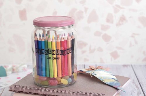 Kleine Geschenkidee zur Einschulung: Einschulung im Glas. Im Glas befinden sich viele kleine Geschenke, wie bunte Stifte, Süßigkeiten und Radiergummis.