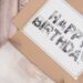 Collage erstellen: Schriftzug Happy Birthday im Deckel einer Geschenkverpackung