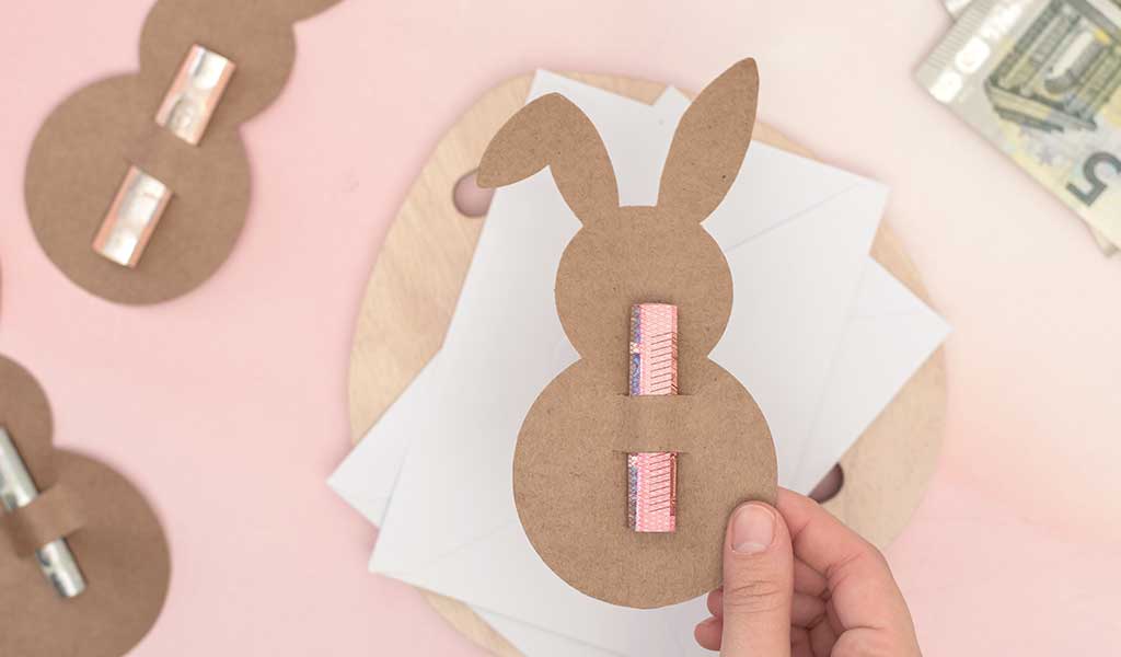 Osterhase aus Pappe in dem ein Geldschein steckt als Geldgeschenk zu Ostern verschenken