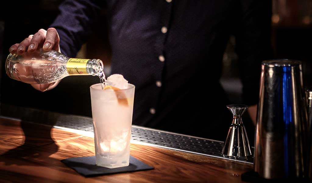 Barkeeper schüttet Cocktail ein